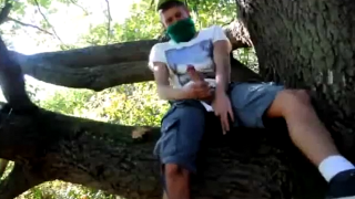Teen boy wanking on tree