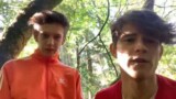 Two young boys fooling around and sucking each other in the woods